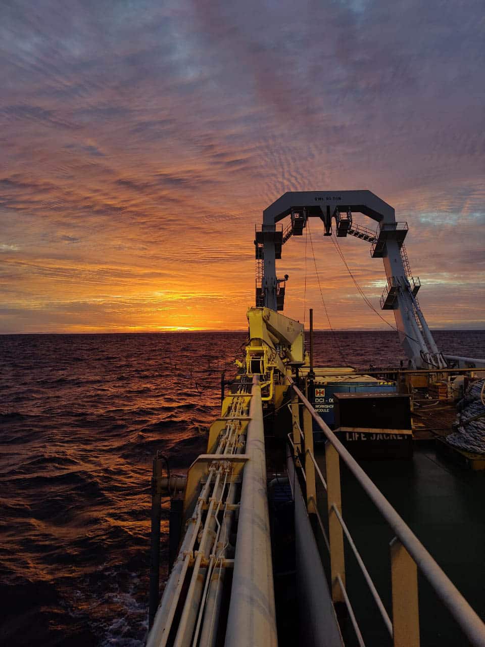 Offshore-Energieinfrastruktur und Kabelverlegeausrüstung bei Sonnenuntergang